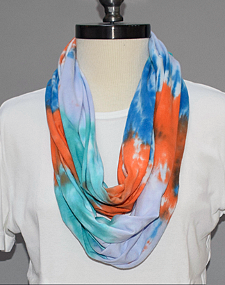 A mannequin wearing a circular scarf that is about 24 inches long.  It has been tie-died, and looks very professional.  It is easy to see this used with a dress-suit or pants-suit.